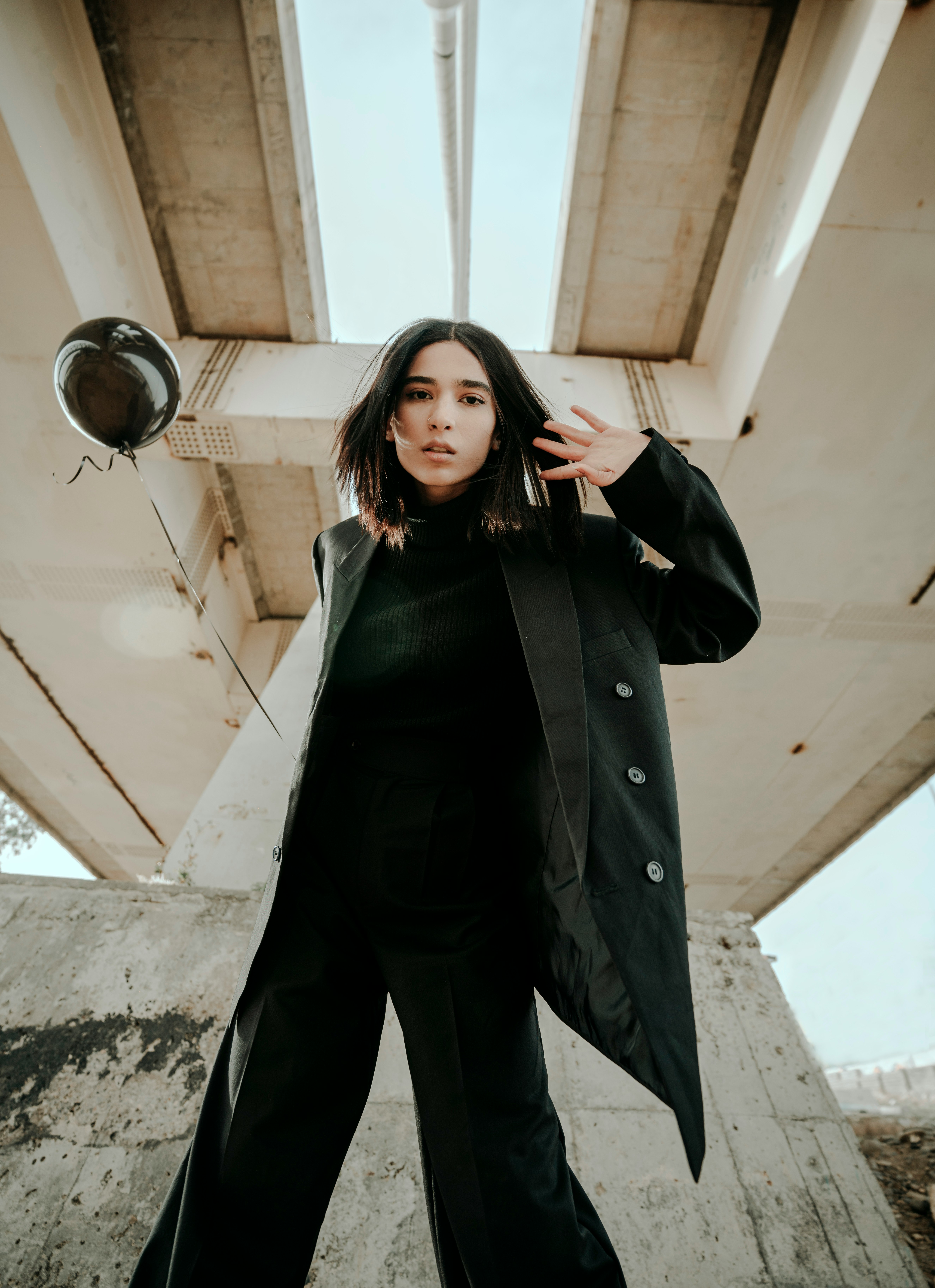 woman in black coat standing on gray concrete stairs during daytime